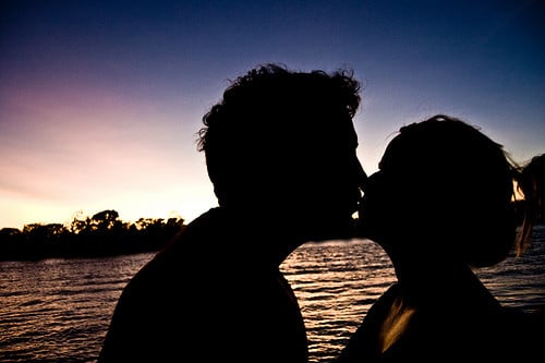 kissing behind a sunset