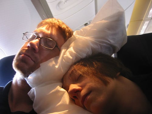 two people sleeping on a plane
