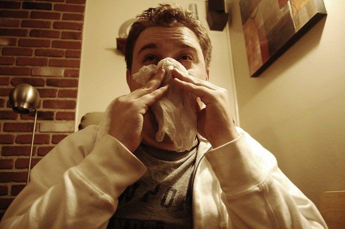 man blowing nose